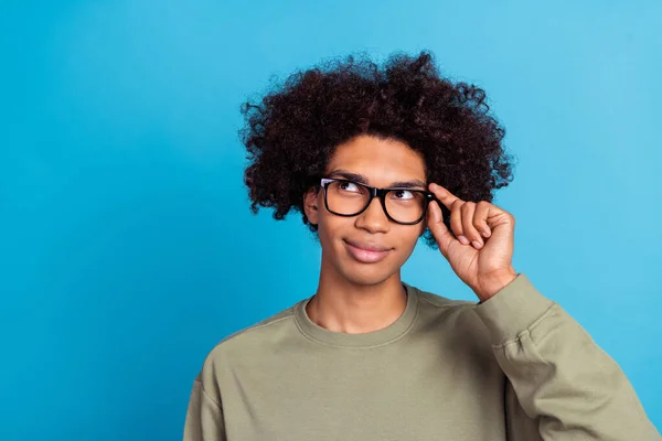 Photo of young man wonder look empty space think smart idea hand touch specs isolated over blue color background — Stockfoto