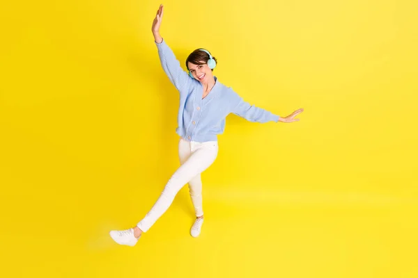 フル体上上高い角度写真の若い女の子幸せなリッスン音楽イヤフォン孤立上黄色色背景 — ストック写真