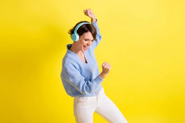 Foto de señora danza boca abierta divertirse usar auriculares azul cárdigan aislado color amarillo fondo — Foto de Stock