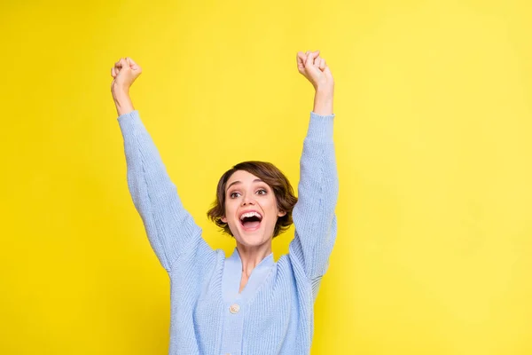 Foto van vrolijke opgewonden dame open mond verhogen handen dragen blauwe vest geïsoleerde gele kleur achtergrond — Stockfoto