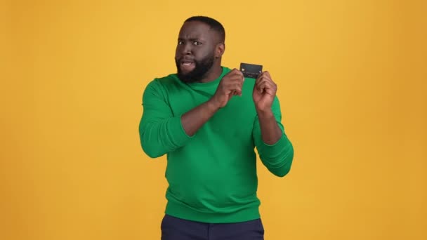Веселий хлопець тримає пропозицію кредитної картки ізольований яскравий кольоровий фон — стокове відео