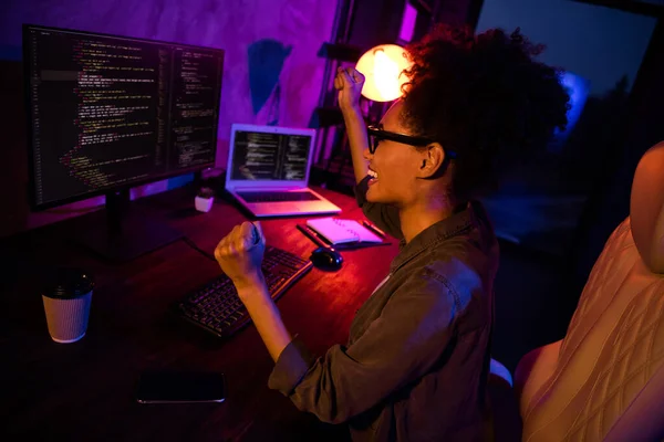 Photo of crazy lady freelancer use device develop java script fists up sit desk evening late in workspace workplace — стоковое фото