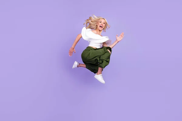 Повна довжина тіла дівчина стрибає вгору на продаж повсякденний одяг ізольований пастельний фіолетовий кольоровий фон — стокове фото