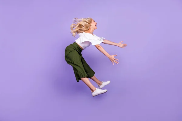 Full length body size girl jumping up laughing flying on wind isolated pastel purple color background — стоковое фото