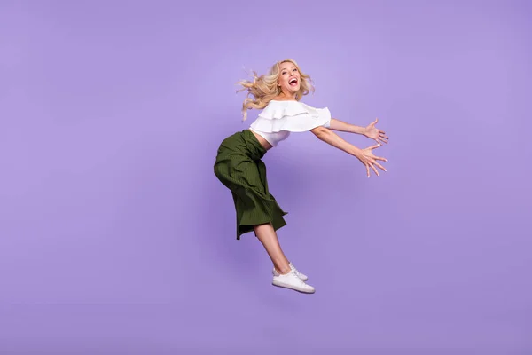 フル長さ体サイズ女の子ジャンプアップ笑う上に飛んで上の風で悪天候隔離されたパステルパープル色の背景 — ストック写真