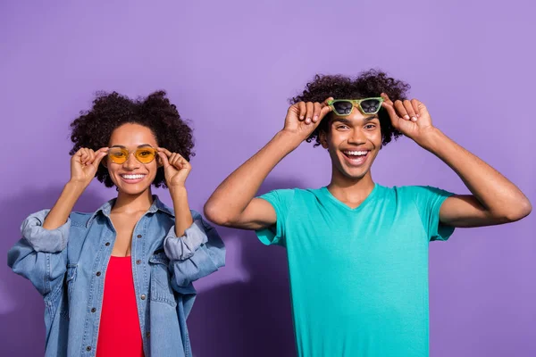 Фотографія веселих веселих молодих африканців носять сонячне скло, яке виглядає ізольованим на фіолетовому фоні. — стокове фото