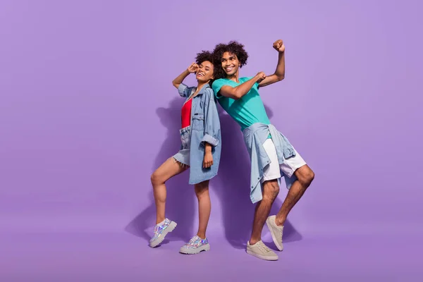 Foto de larga duración de fresco feliz piel oscura positiva pareja mirada espacio vacío danza aislada sobre fondo de color púrpura —  Fotos de Stock