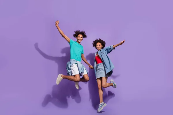 Pełne ciało zdjęcie fajne wesołe afro amerykańskiej pary skakać cieszyć się izolowane na fioletowym tle koloru — Zdjęcie stockowe