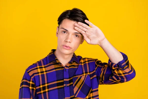 Fotografie unavené rozrušený dospívající chlapec nosit kostkované oblečení ruka čelo izolované žlutá barva pozadí — Stock fotografie