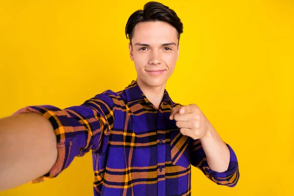 Foto di fiducioso dolce teen boy indossare abito scozzese prendendo selfie dito che indica isolato sfondo di colore giallo — Foto Stock