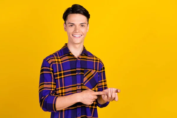 Foto de legal morena millennial cara contagem desgaste xadrez camisa isolada no fundo de cor amarela — Fotografia de Stock