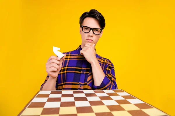 Foto van millennial denken guy spelen schaak dragen geruite shirt bril geïsoleerd op gele kleur achtergrond — Stockfoto