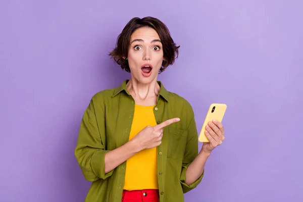 Foto van jonge verbaasd dame duiden vinger mobiele reactie beslissing 4g geïsoleerd over violette kleur achtergrond — Stockfoto