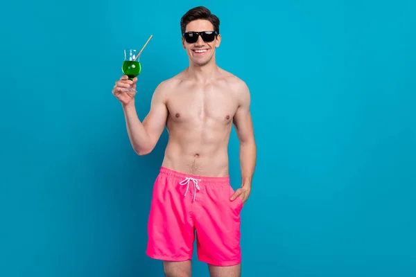 Φωτογραφία του ενθουσιασμένοι όμορφη νεαρός γυμνόστηθη χαμογελώντας πόσιμο πράσινο κοκτέιλ απομονωμένο φόντο μπλε χρώμα — Φωτογραφία Αρχείου