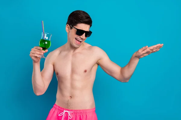 写真の面白い魅力的な若い男裸の胴ダークグラス保持カクテルダンス笑顔隔離された青の色の背景 — ストック写真