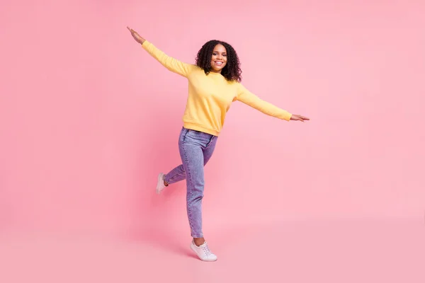 Foto av drömmande funky mörk hud kvinna bära gul tröja promenader armar sidor isolerad rosa färg bakgrund — Stockfoto