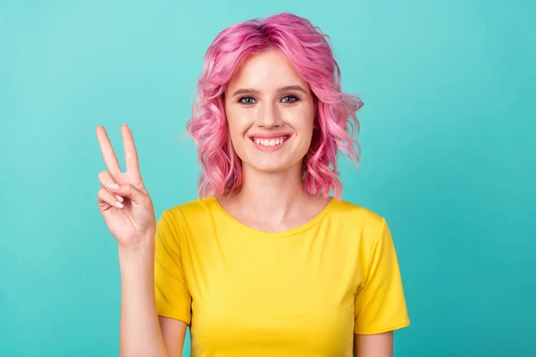 Zdjęcie młody funky różowa fryzura pani pokazać v-sign nosić żółty t-shirt izolowane na tle morskim — Zdjęcie stockowe