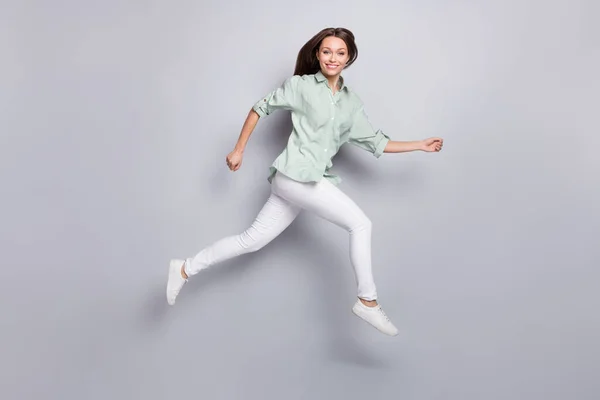 Фотографія профілю повного розміру смішної брюнетки леді біжить носити блузки штани взуття ізольовані на сірому кольоровому фоні — стокове фото