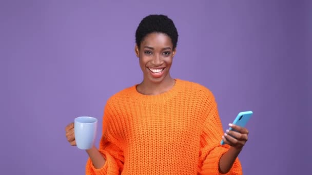 Férfi nő személy inni kakaó használat eszköz elszigetelt lila szín háttér — Stock videók