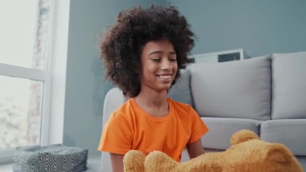 Roztomilé dítě sedět koberec hrát oblíbené hračky objetí v obývacím pokoji byt — Stock video