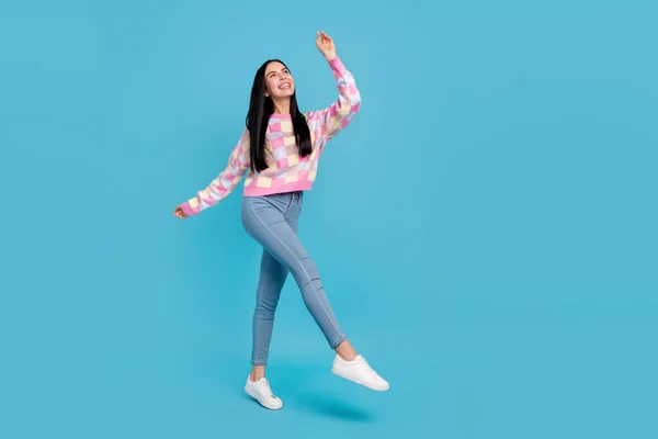 Foto di infantile sognante giovane donna indossare maglione rosa ballare camminando cercando spazio vuoto isolato colore blu sfondo — Foto Stock