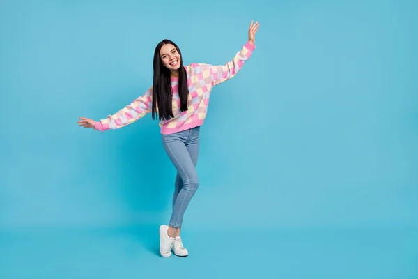 Foto de mujer joven infantil excitada usando suéter rosa bailando espacio vacío aislado color azul fondo —  Fotos de Stock