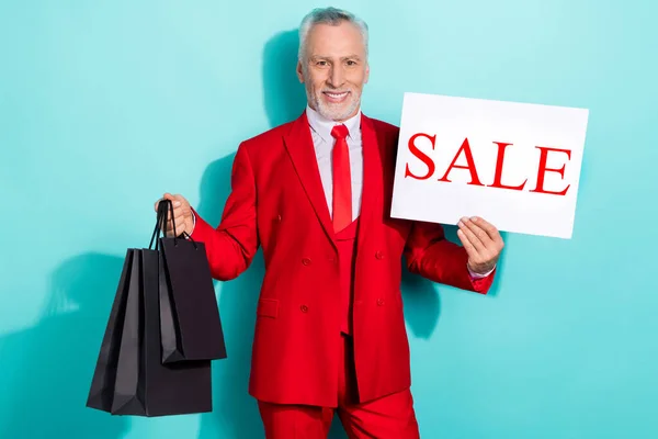 Фото позитивного чоловіка пенсіонера, одягненого в червоний три штуки, що тримає продажу картки ізольованого кольору сльози — стокове фото