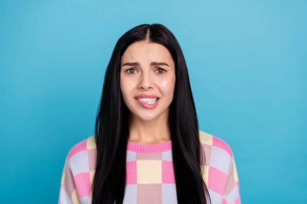 Foto de culpado assustado jovem mulher desgaste rosa suéter mordendo lábio isolado azul cor de fundo — Fotografia de Stock