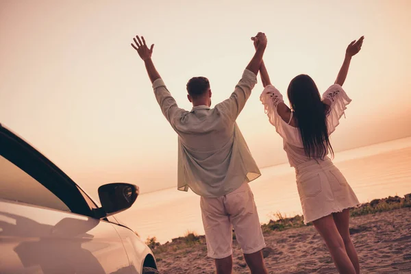 Volver vista trasera foto de pareja joven disfrutar de la fecha de luna de miel vacaciones junto al mar la libertad de coche tomarse de la mano el verano al aire libre —  Fotos de Stock