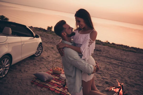 Foto ritratto coppia ridere abbracciando al tramonto indossando abiti casual trascorrere del tempo sulla spiaggia — Foto Stock