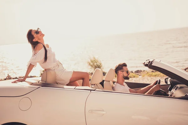 Profil yan görüntüsü: Çekici, neşeli, hayalperest bir çift araba kullanıyor. Hafta sonunu dışarıda eğlenerek geçiriyor. — Stok fotoğraf