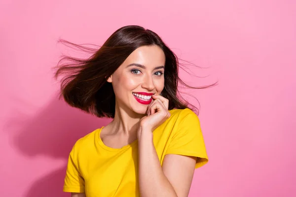 Foto de dulce encantadora mujer joven llevar traje amarillo soplado de aire dedo mordedor sonriente aislado color rosa fondo — Foto de Stock