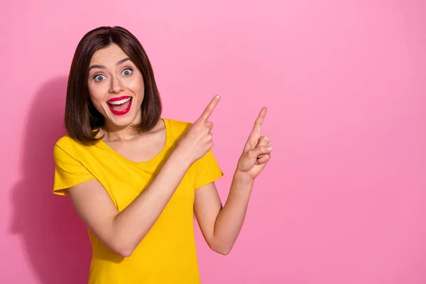 Photo of cute impressed young woman wear yellow outfit pointing two fingers empty space open mouth isolated pink color background — Stock Photo, Image