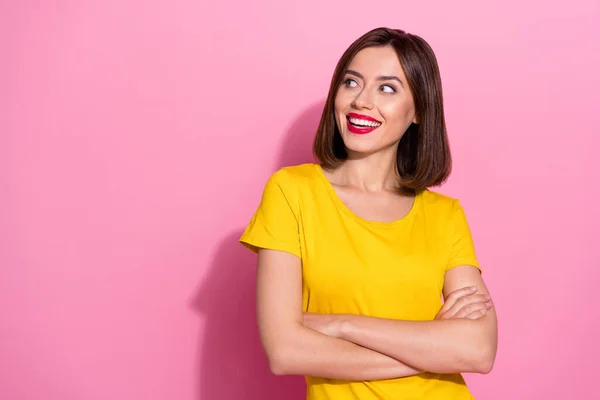 Foto de encantadora mujer joven de ensueño usar brazos de traje amarillo cruzados buscando espacio vacío sonriendo aislado color rosa fondo — Foto de Stock