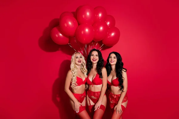 Portret van boom aantrekkelijke vrolijke meisjes met helium ballen feestelijke themafeest geïsoleerd over helder rode kleur achtergrond — Stockfoto