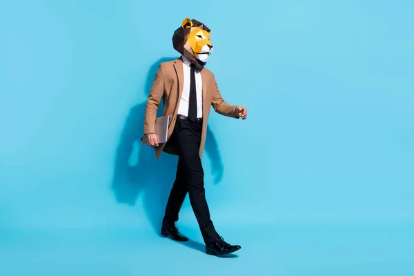Full body profile side photo of freak bizarní anonym guy lion mask go hold netbook isolated over blue color background — Stock fotografie