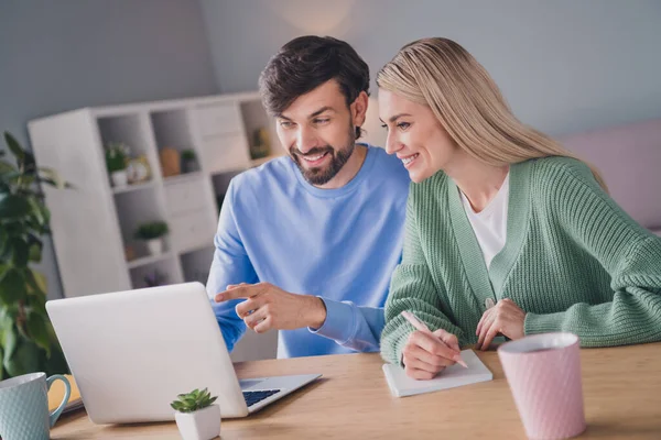 Retrato de dos personas alegres atractivas usando el ordenador portátil que elige el servicio de la tela de las mercancías de la orden en el interior casero — Foto de Stock