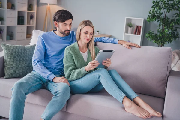 Retrato de duas pessoas atraentes focadas sentadas no divã passar fim de semana usando dispositivo gadget assistindo vídeo de tv em casa dentro de casa — Fotografia de Stock