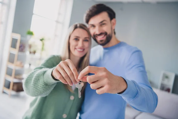 Retrato de dos personas alegres atractivas parejas que se unen sosteniendo en las manos la llave de un nuevo piso en casa en el interior —  Fotos de Stock