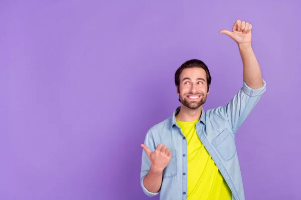Photo de jeune homme souriant rêveur regarder copyspace publicité produit montrant pouce vers le haut isolé sur fond de couleur violette — Photo