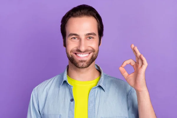 Zdjęcie wesołego pozytywnego atrakcyjnego faceta pokazując okay gest aprobaty izolowane na fioletowym tle koloru — Zdjęcie stockowe