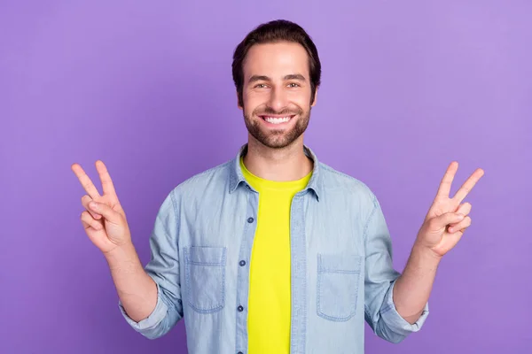 Photo d'un gars souriant et joyeux montrant une chemise en denim à double enseigne en V isolé sur fond de couleur violette — Photo