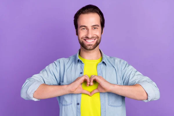 긍정적 이고 잘생긴 남자가 보라색 배경에 고립된 심장의 상징을 보여 주는 그림 — 스톡 사진