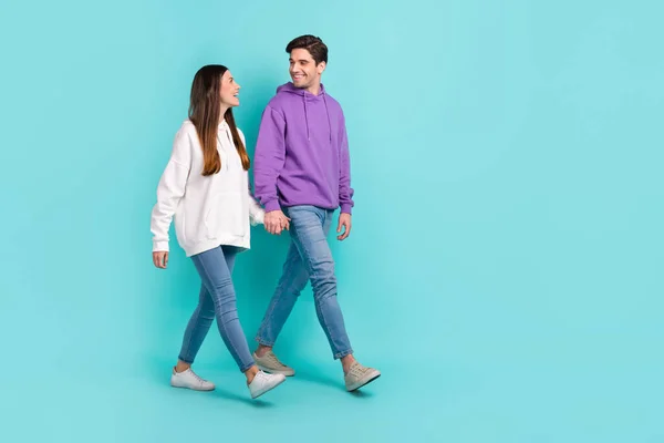 Foto em tamanho completo de casal casual desgaste ir na data segurando as mãos dizendo piadas rindo isolado no fundo de cor azul — Fotografia de Stock