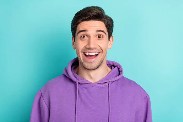 Фото впечатлённого фанки молодого человека с фиолетовой толстовкой, улыбающегося открытым ртом, изолированный голубой фон — стоковое фото