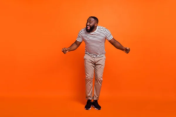 Plná délka fotografie mladého nadšeného afrického muže bavit výkon izolované přes oranžové barvy pozadí — Stock fotografie
