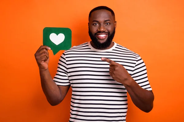 Foto de chico africano guapo joven dedo tarjeta de papel comentario botón de clic seleccionar sugerir aislado sobre fondo de color naranja — Foto de Stock