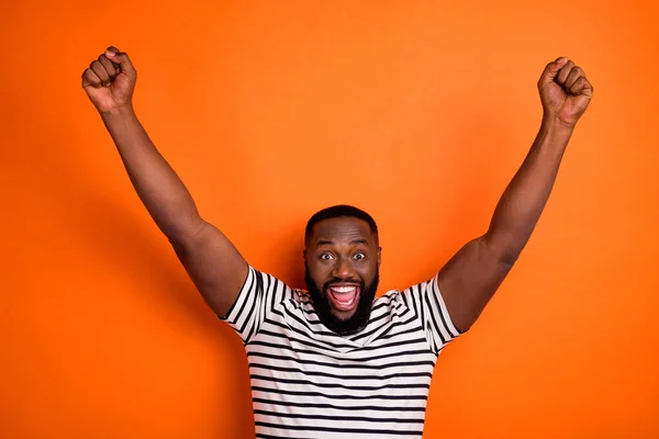 Foto av unga glada afrikanska killen glädja framgång nävar händer triumf fläkt stöd isolerad över orange färg bakgrund — Stockfoto