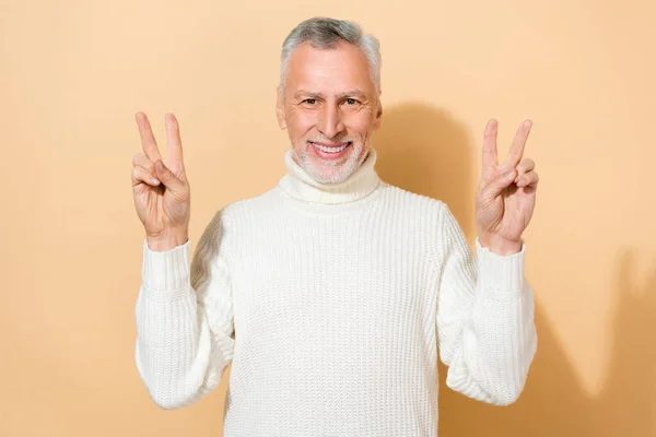 Porträtt av attraktiva glada gråhårig man visar dubbel v-tecken gott humör isolerad över beige pastell färg bakgrund — Stockfoto