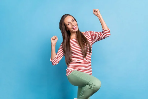 Foto di giovane ragazza allegra divertirsi gioire vittoria pugni mani felice isolato su sfondo di colore blu — Foto Stock